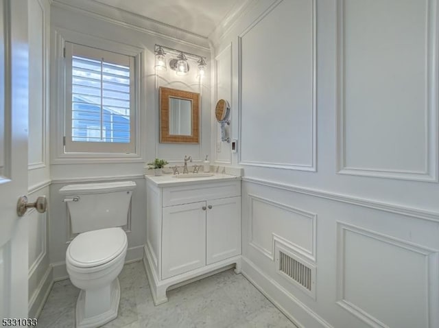 bathroom with toilet, crown molding, and vanity