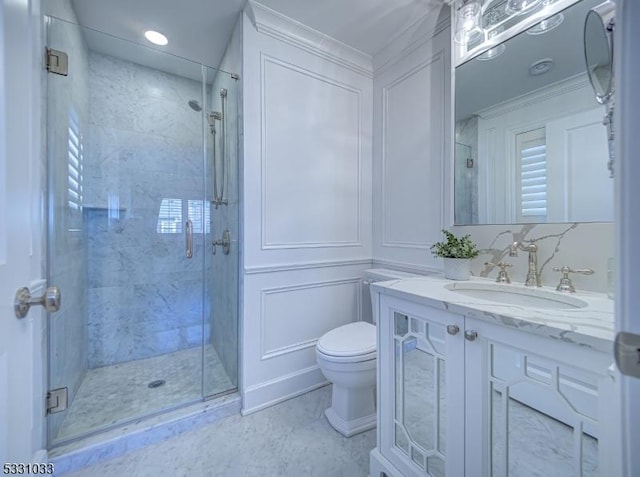 bathroom featuring walk in shower, vanity, crown molding, and toilet