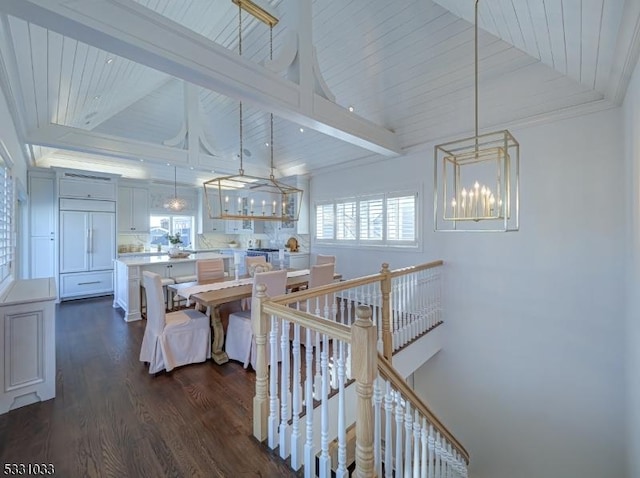 interior space with lofted ceiling, wood-type flooring, a wealth of natural light, and an inviting chandelier