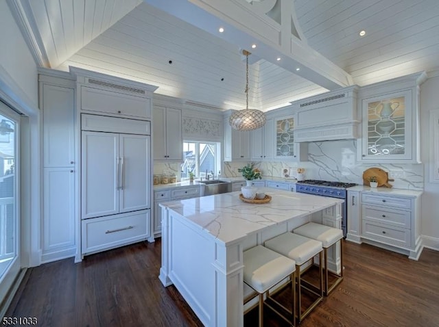 kitchen with a kitchen island, lofted ceiling, tasteful backsplash, and decorative light fixtures