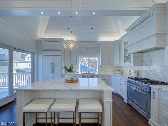 kitchen with decorative light fixtures, gas range oven, a breakfast bar area, and a kitchen island