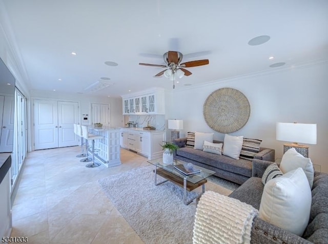 tiled living room featuring ceiling fan and crown molding