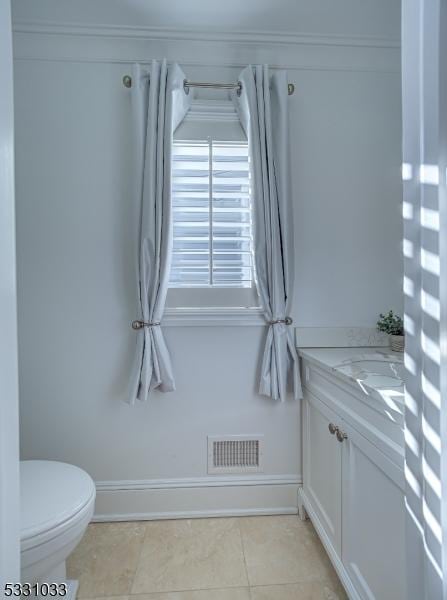 bathroom with toilet, tile patterned flooring, and vanity