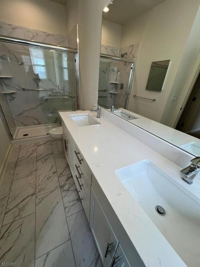 bathroom with a shower with door, vanity, and toilet