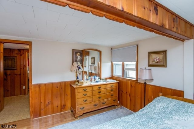 bedroom with wood walls and light wood-type flooring