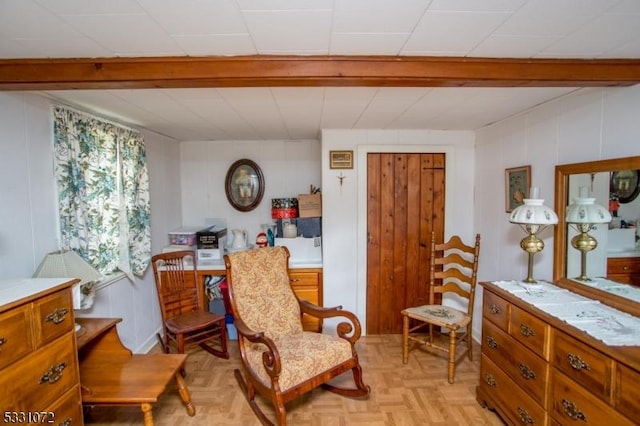 sitting room with wood walls and light parquet flooring