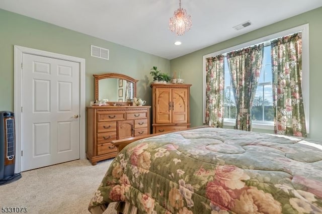 bedroom with light colored carpet and an inviting chandelier