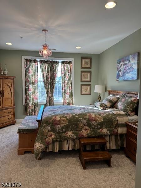 bedroom with a chandelier and light colored carpet