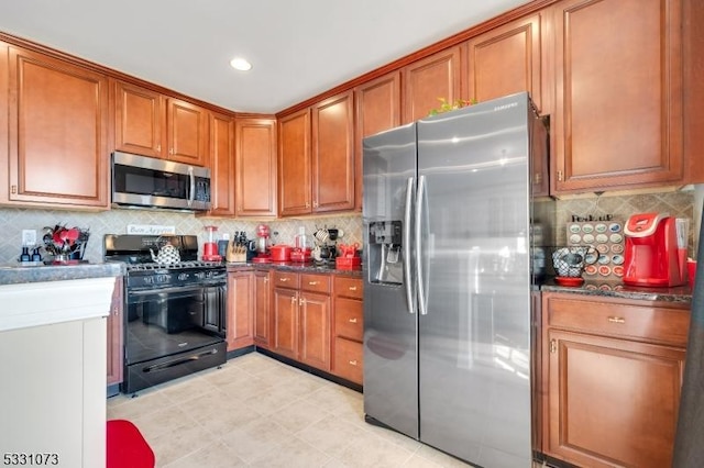 kitchen featuring backsplash, dark stone counters, and stainless steel appliances