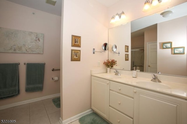 bathroom featuring tile patterned floors, a shower with door, and vanity