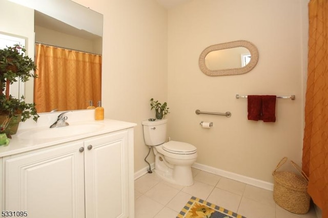 bathroom with tile patterned flooring, vanity, and toilet