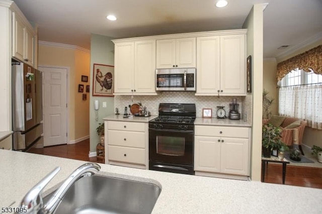 kitchen featuring tasteful backsplash, sink, ornamental molding, and appliances with stainless steel finishes