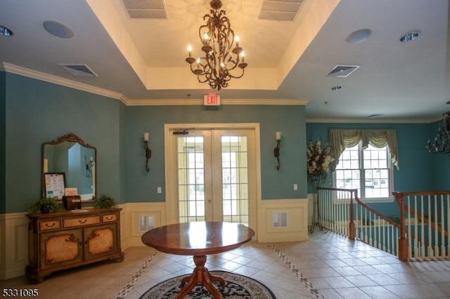 doorway featuring french doors, a raised ceiling, ornamental molding, and light tile patterned flooring