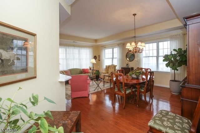 dining space with a wealth of natural light, hardwood / wood-style floors, and a chandelier