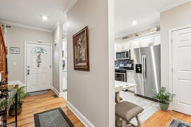 foyer with light wood-type flooring and ornamental molding