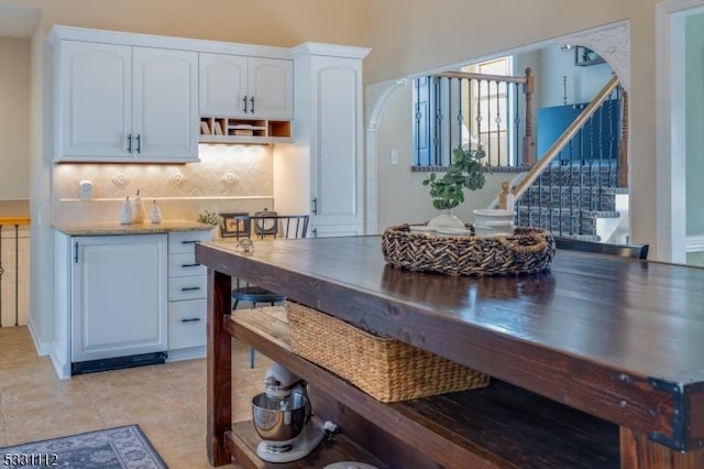 kitchen featuring white cabinets, light tile patterned flooring, and tasteful backsplash