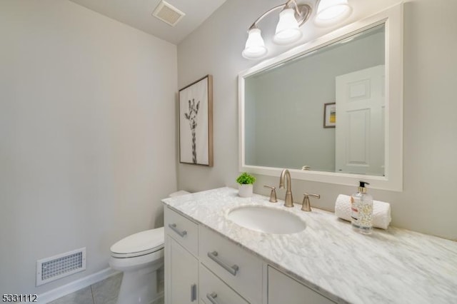 bathroom with tile patterned flooring, vanity, and toilet