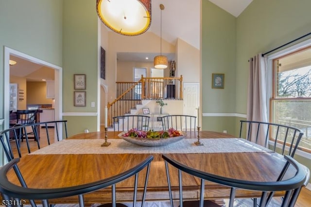 dining space featuring high vaulted ceiling