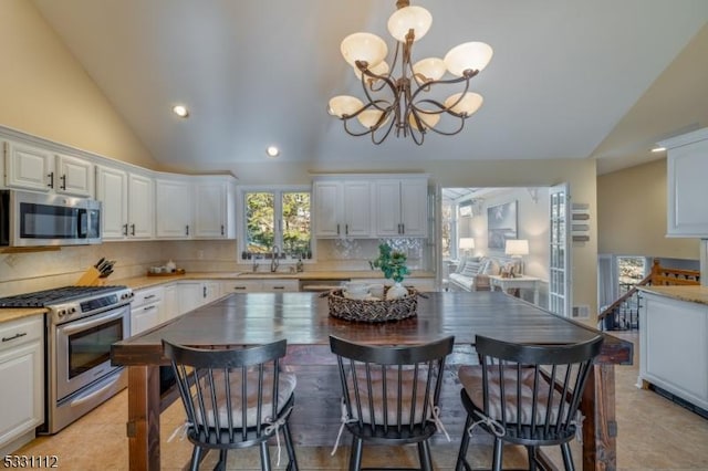 kitchen with white cabinets, an inviting chandelier, backsplash, pendant lighting, and appliances with stainless steel finishes