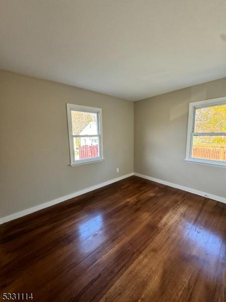 spare room with dark hardwood / wood-style flooring