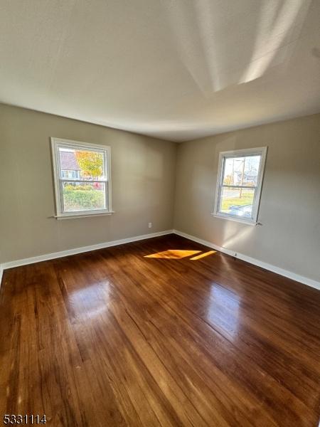 unfurnished room with dark hardwood / wood-style floors