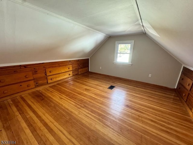 bonus room with light wood-type flooring and lofted ceiling