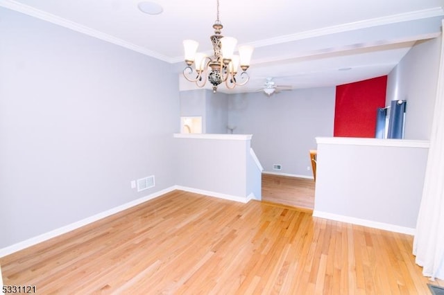 empty room with ceiling fan with notable chandelier, hardwood / wood-style flooring, and ornamental molding