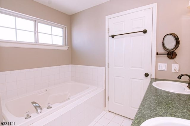 bathroom featuring tile patterned floors, tiled bath, and vanity