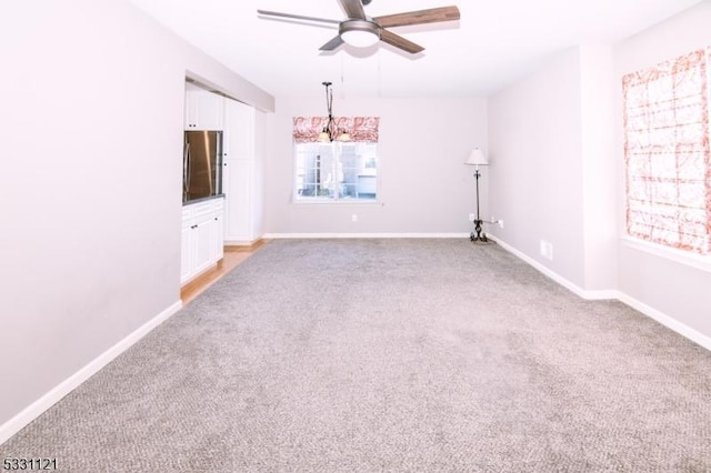 empty room with light colored carpet and ceiling fan