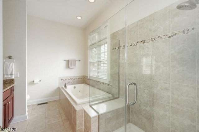 bathroom featuring plus walk in shower, vanity, and tile patterned floors