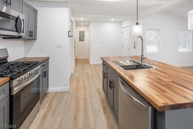 kitchen with wooden counters, appliances with stainless steel finishes, gray cabinets, and sink