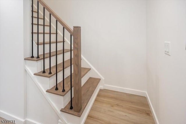 stairway with hardwood / wood-style floors