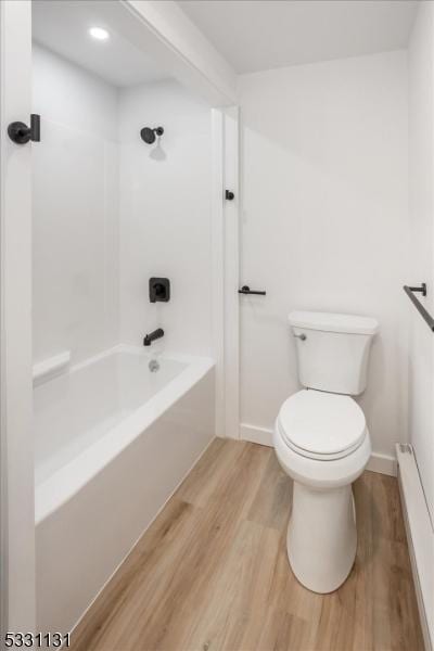 bathroom with hardwood / wood-style floors, shower / bath combination, and toilet