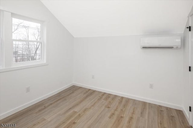 bonus room featuring a wall unit AC, lofted ceiling, and light wood-type flooring