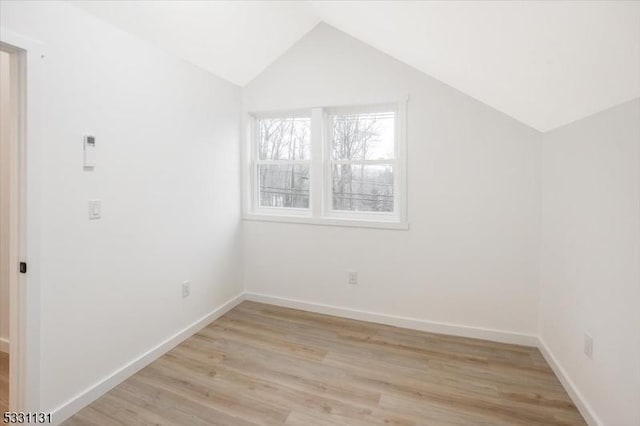 bonus room featuring light wood-type flooring and vaulted ceiling