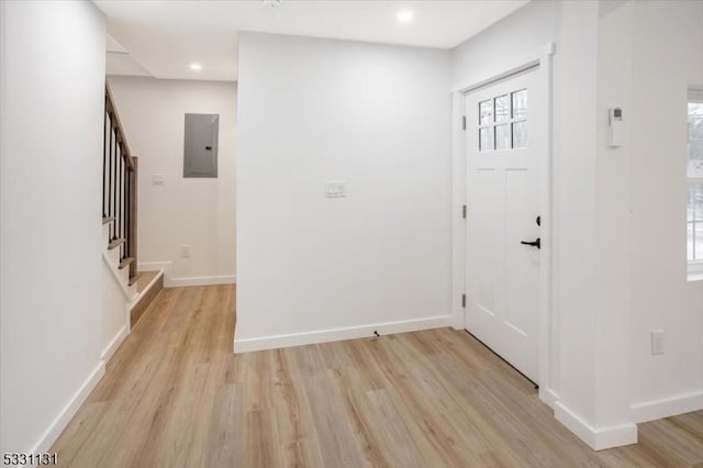 foyer entrance with light wood-type flooring and electric panel