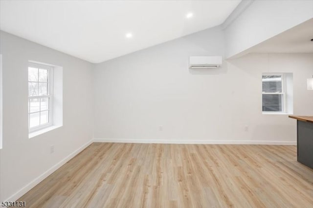 interior space featuring light wood-type flooring and an AC wall unit