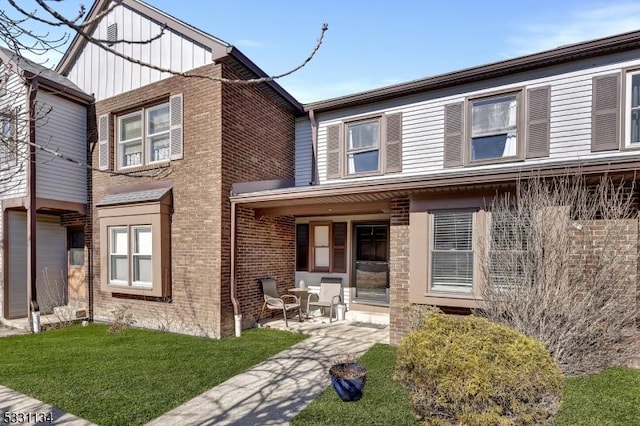 view of front facade with brick siding and a front lawn