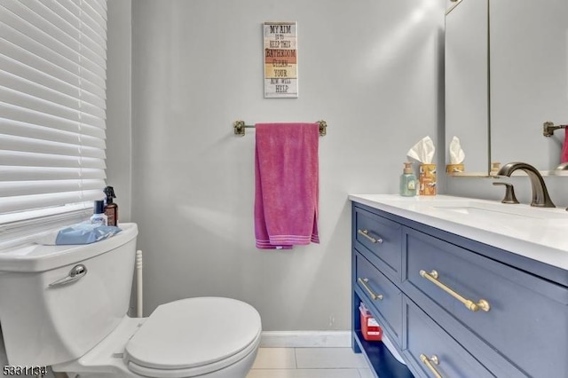 bathroom with toilet, tile patterned flooring, baseboards, and vanity