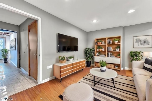 living area with light wood-style flooring, baseboards, and recessed lighting