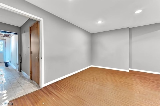 basement with light wood-type flooring, baseboards, and recessed lighting