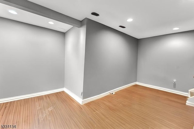 spare room featuring baseboards, wood finished floors, and recessed lighting