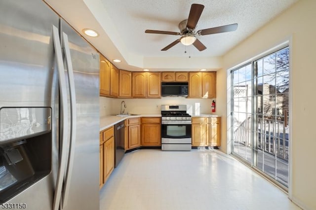 kitchen with a textured ceiling, ceiling fan, sink, and appliances with stainless steel finishes