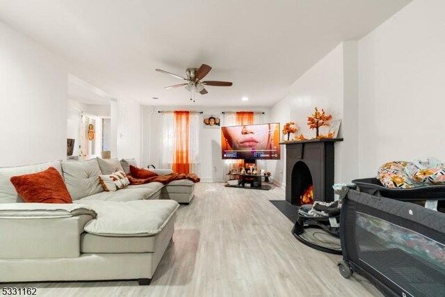 living room featuring ceiling fan and light hardwood / wood-style floors