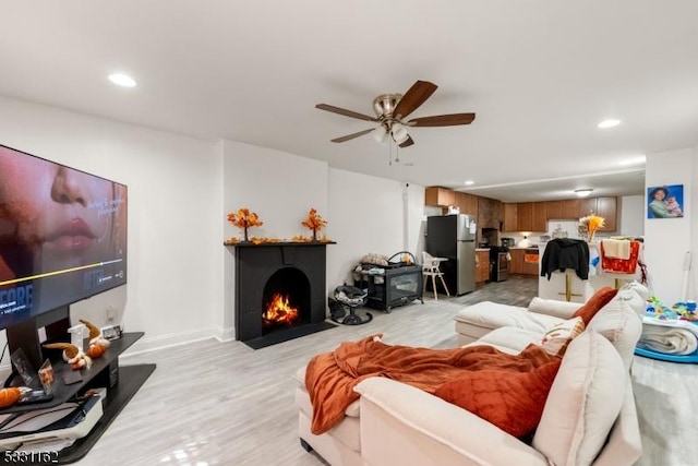 living room featuring ceiling fan and light wood-type flooring