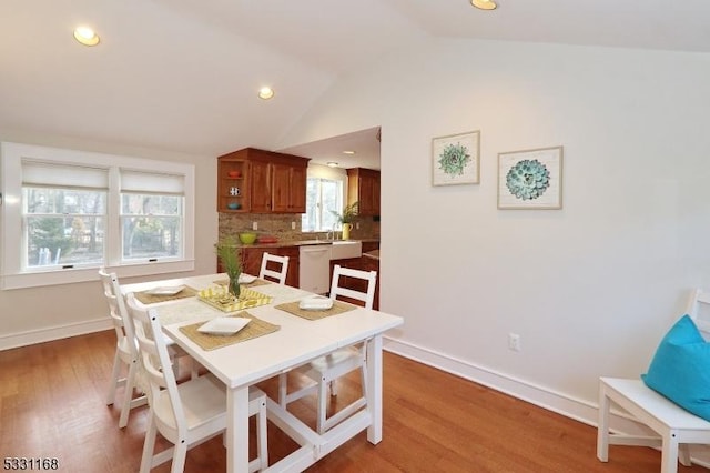 dining area with light wood-type flooring, baseboards, vaulted ceiling, and recessed lighting