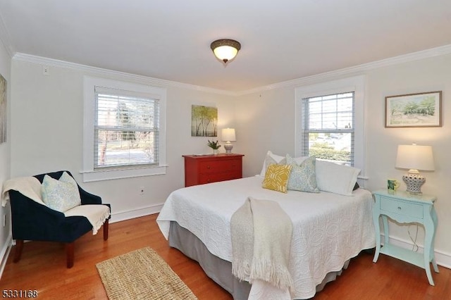 bedroom with baseboards, crown molding, and wood finished floors