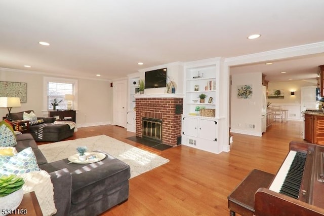 living room featuring built in features, ornamental molding, wood finished floors, a brick fireplace, and recessed lighting