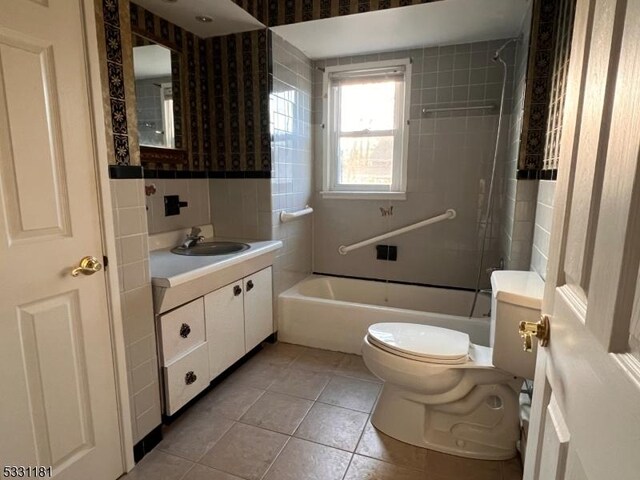 full bathroom with tile patterned flooring, vanity, tiled shower / bath combo, and toilet