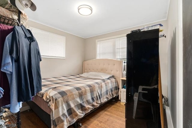 bedroom featuring ornamental molding and hardwood / wood-style flooring